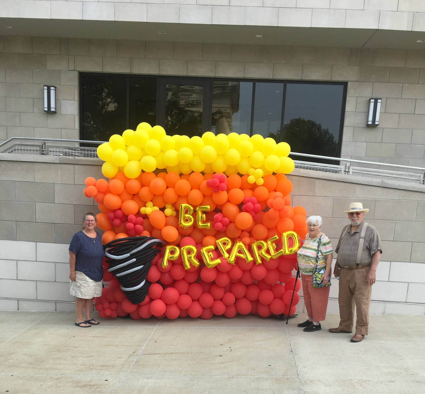 Julie Bradford and Alice and Bill Wichern smile for a photo in front of the Be Prepared Balloon Wall while enjoying the day’s festivities.
